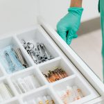 Gaveta esterilizada com instrumentos médicos e seringas organizados em uma clínica