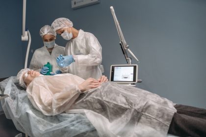 Dois médicos realizam um procedimento estético em uma paciente dentro de uma clínica.