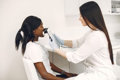 Profissional realiza análise da pele do rosto de uma paciente com equipamento em uma clínica.