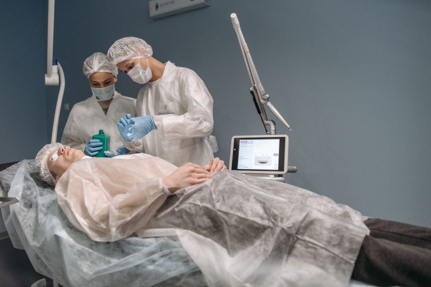 Dois profissionais de saúde realizam um tratamento estético em uma paciente dentro de uma clínica.
