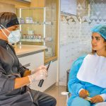 Dentista conversa com paciente em uma clínica odontológica moderna durante uma consulta.
