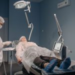 Profissional de saúde realiza procedimento estético com laser em paciente, em ambiente clínico.