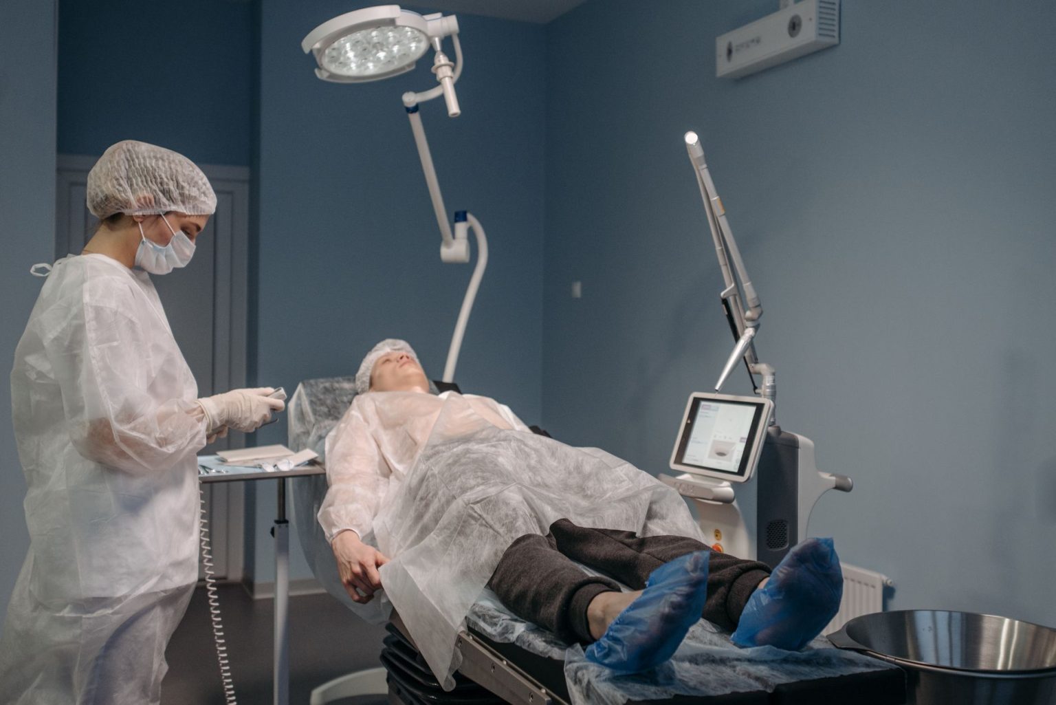 Profissional de saúde realiza procedimento estético com laser em paciente, em ambiente clínico.