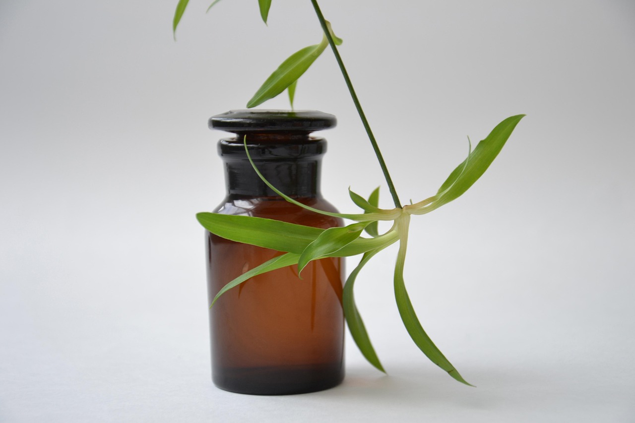 Frascos de vidro e utensílios de laboratório usados na preparação e análise de ingredientes cosméticos.